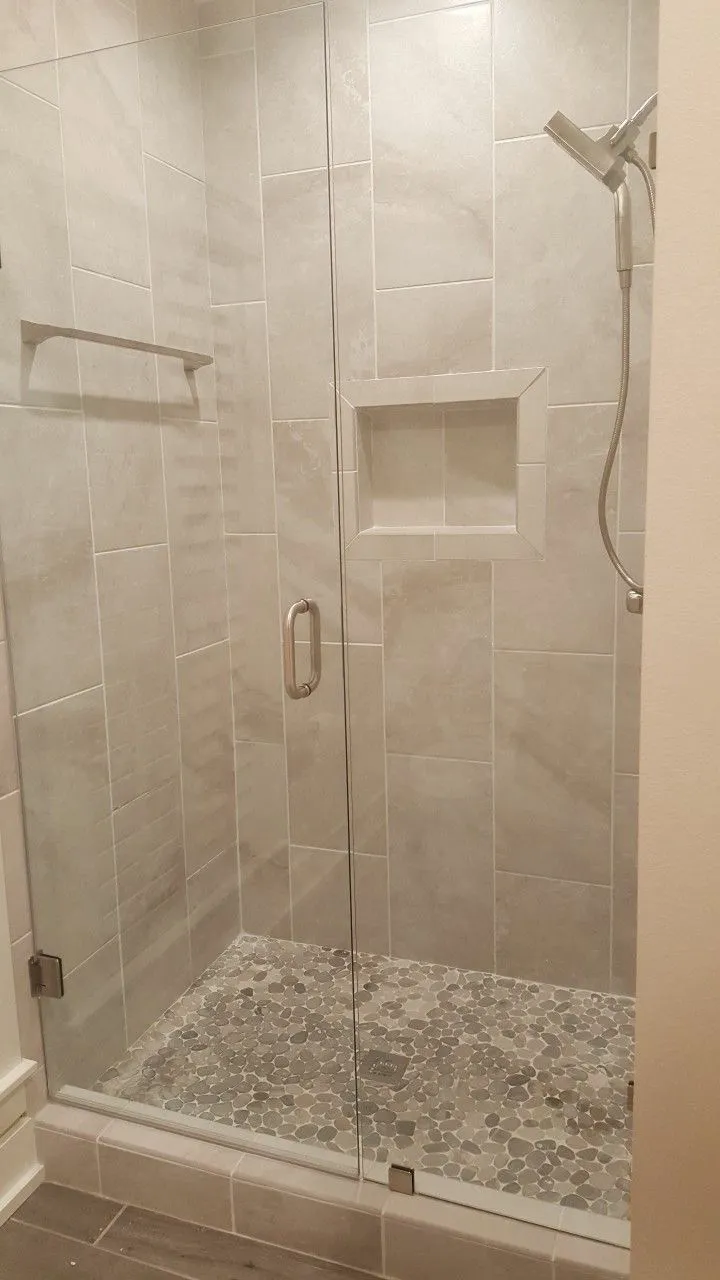 Glass-enclosed modern shower with tiled walls