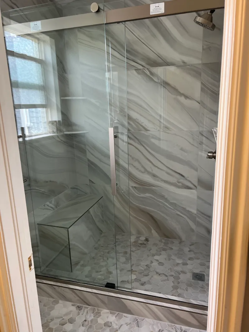 Modern glass shower with marble walls