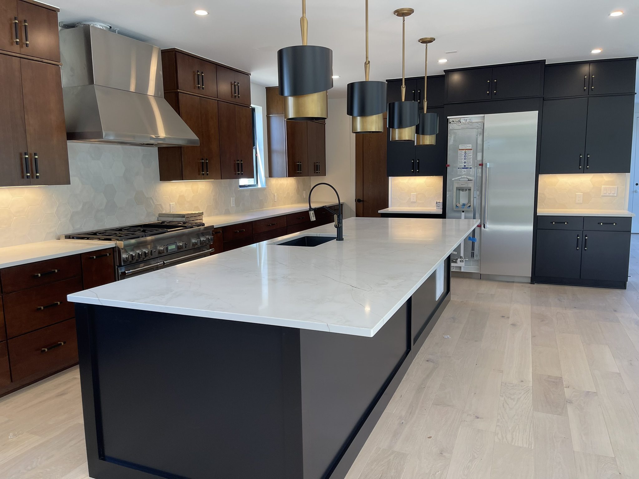 Modern kitchen with sleek island and pendant lights.