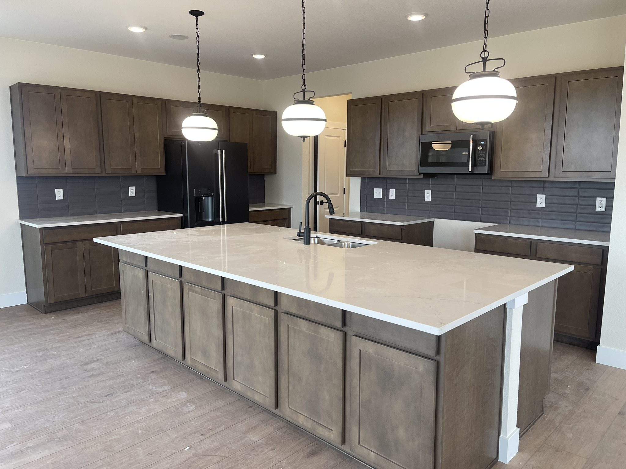 Modern kitchen with a large island and pendant lights.